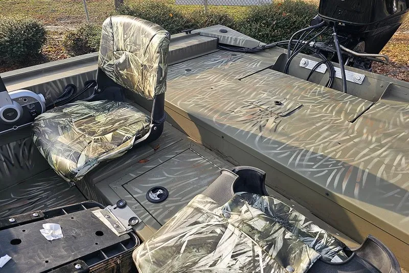Slide: The Image of 2024 Tracker Grizzly 1754 SC boat interior with camouflage seats and deck. - 11