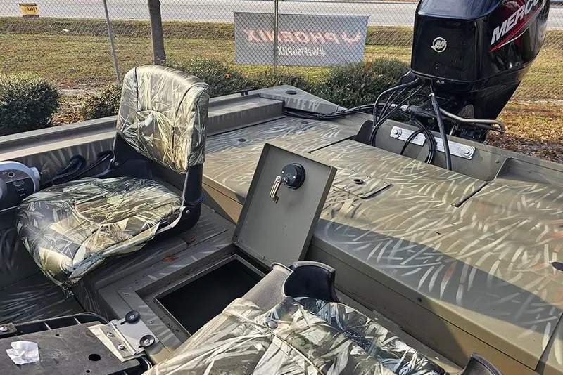 Slide: The Image of 2024 Tracker Grizzly 1754 SC boat interior with camo seats and Mercury outboard motor. - 12