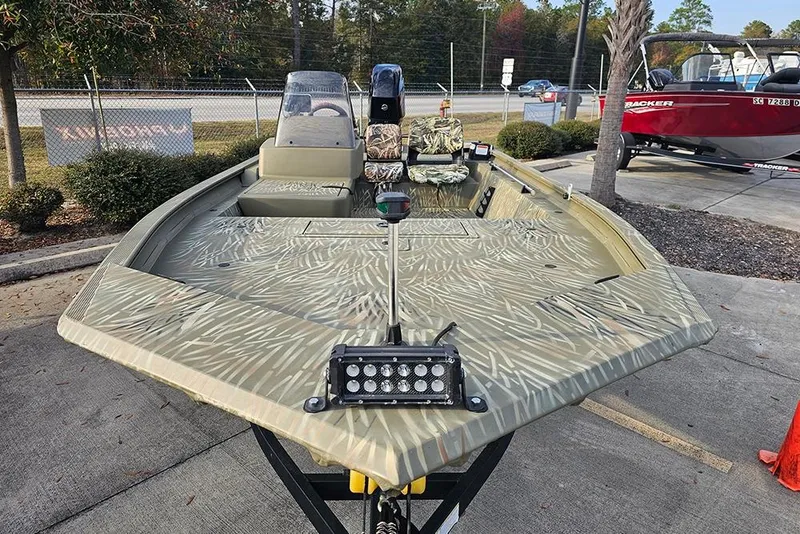 Slide: The Image of 2024 Tracker Grizzly 1754 SC boat with camouflage design on display outdoors. - 4