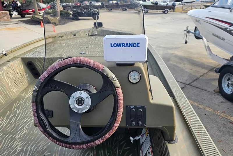 Slide: The Image of 2024 Tracker Grizzly 1754 SC boat dashboard with Lowrance device and steering wheel. - 8