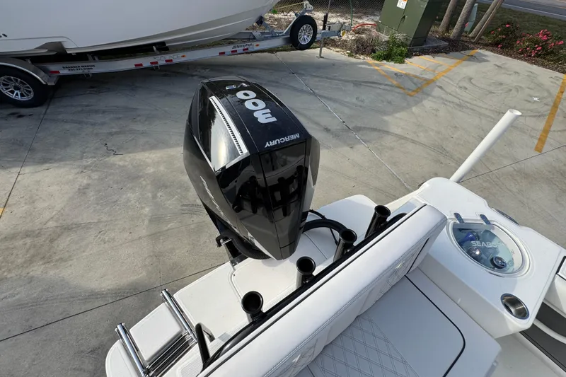 Slide: The Image of 2026 Sea Born LX24 Center Console with Mercury outboard engine, parked on concrete. - 47