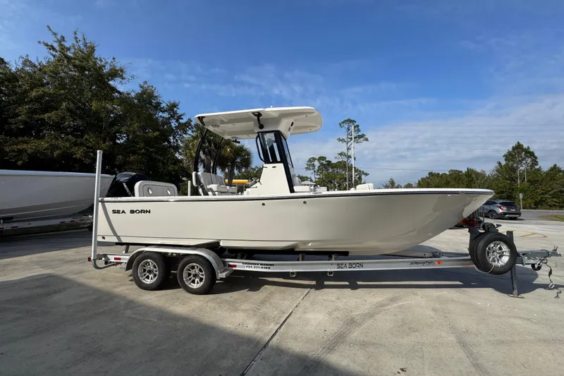 Slide: The Image of 2026 Sea Born LX24 Center Console boat on trailer, parked outdoors. - 9