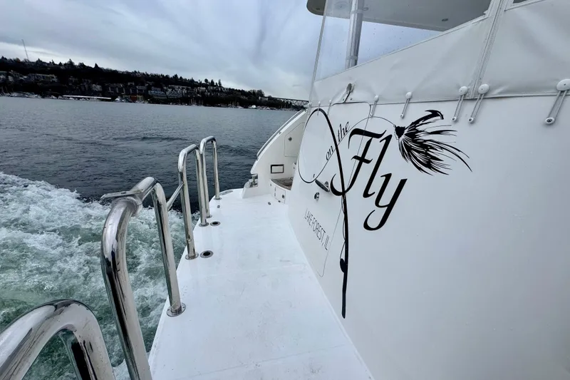 Slide: The Image of 2013 Hampton 620 Pilothouse yacht with "On the Fly" design, cruising on a lake. - 10