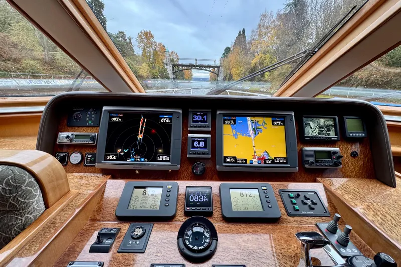 Slide: The Image of Hampton 620 Pilothouse 2013 dashboard with navigation screens and controls, scenic river view. - 19
