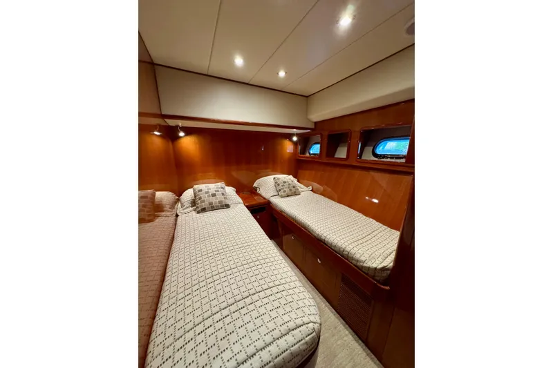 Slide: The Image of Luxurious twin cabin interior of 2013 Hampton 620 Pilothouse yacht, featuring elegant wood paneling. - 24