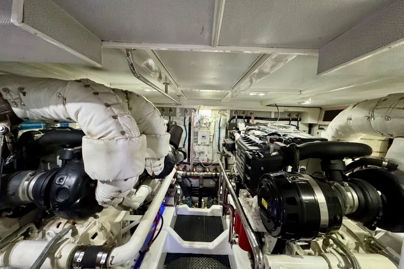 Slide: The Image of Engine room of a 2013 Hampton 620 Pilothouse yacht, showcasing dual engines and mechanical systems. - 26