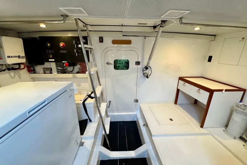 Slide: The Image of Engine room of 2013 Hampton 620 Pilothouse yacht with control panels and storage. - 28