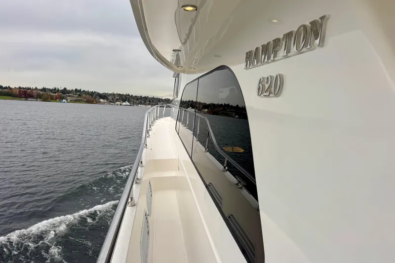 Slide: The Image of 2013 Hampton 620 Pilothouse yacht cruising on a calm lake. - 4