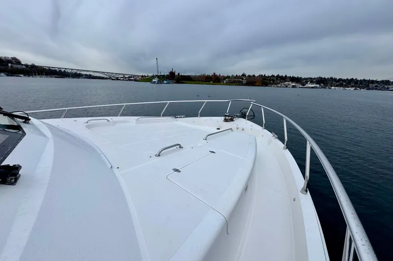 Slide: The Image of Bow view of 2013 Hampton 620 Pilothouse yacht on a calm lake under cloudy skies. - 7