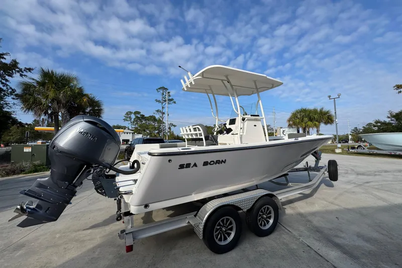Slide: The Image of 2026 Sea Born LX21 Center Console boat on trailer, parked outdoors under blue sky. - 10