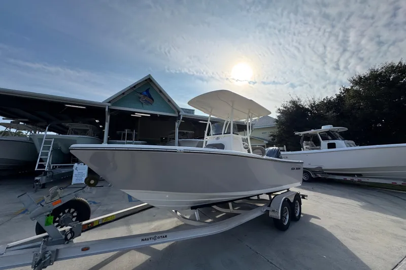 Slide: The Image of 2026 Sea Born LX21 Center Console boat on trailer under sunny sky. - 3