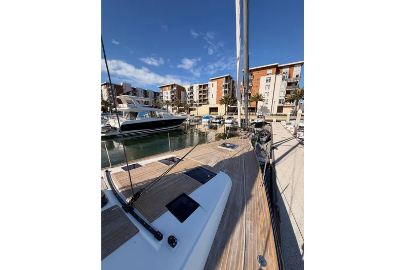 Slide: The Image of Beneteau Oceanis Yacht 60, 2015, docked in marina with modern buildings in background. - 11