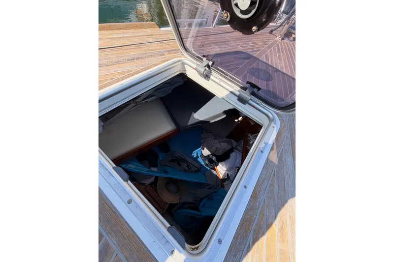 Slide: The Image of Open hatch on Beneteau Oceanis Yacht 60, revealing storage area with various items. - 15