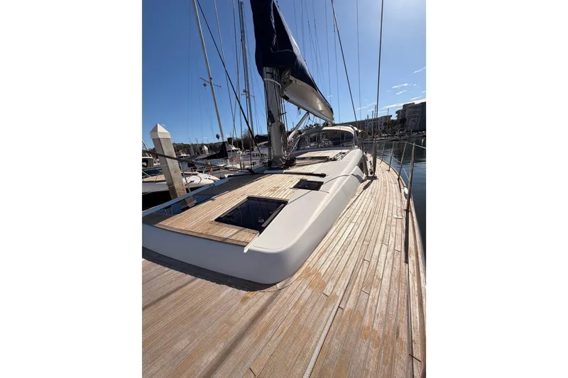 Slide: The Image of Luxurious 2015 Beneteau Oceanis Yacht 60 docked, showcasing sleek deck design under clear skies. - 16