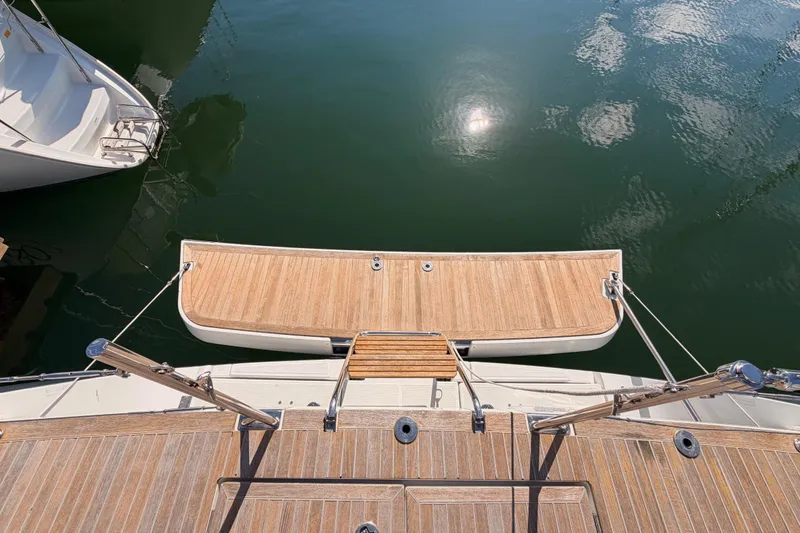 Slide: The Image of Beneteau Oceanis Yacht 60, 2015 model, featuring a wooden swim platform on calm water. - 22