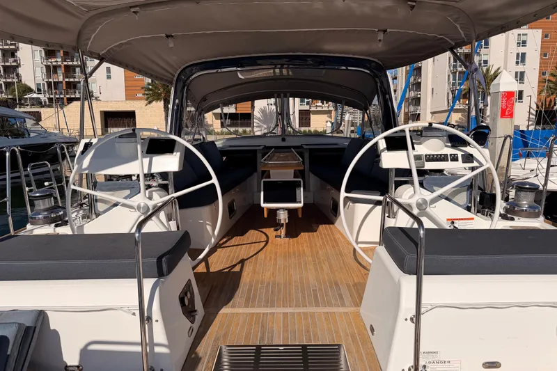 Slide: The Image of Beneteau Oceanis Yacht 60 cockpit, dual steering wheels, spacious seating, docked in marina. - 24