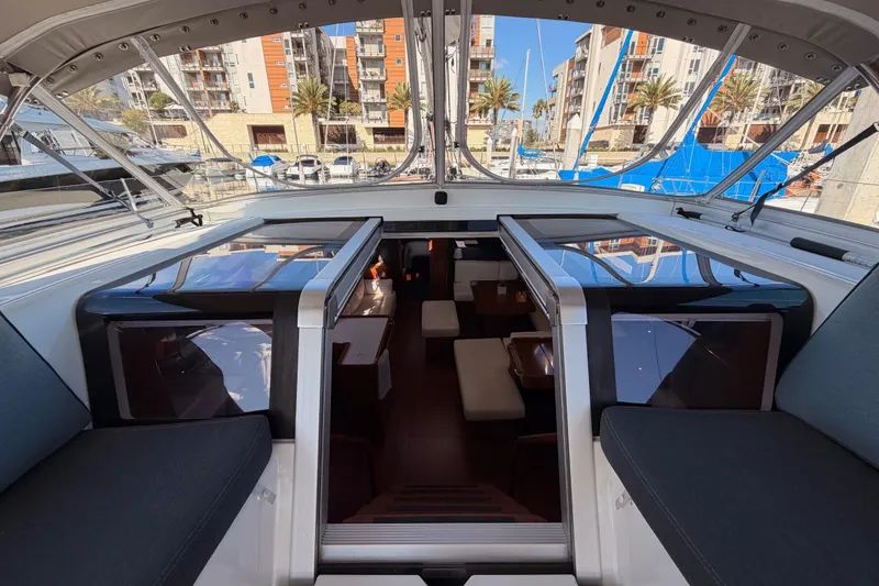 Slide: The Image of Interior view of 2015 Beneteau Oceanis Yacht 60, showcasing luxurious cabin and marina backdrop. - 36