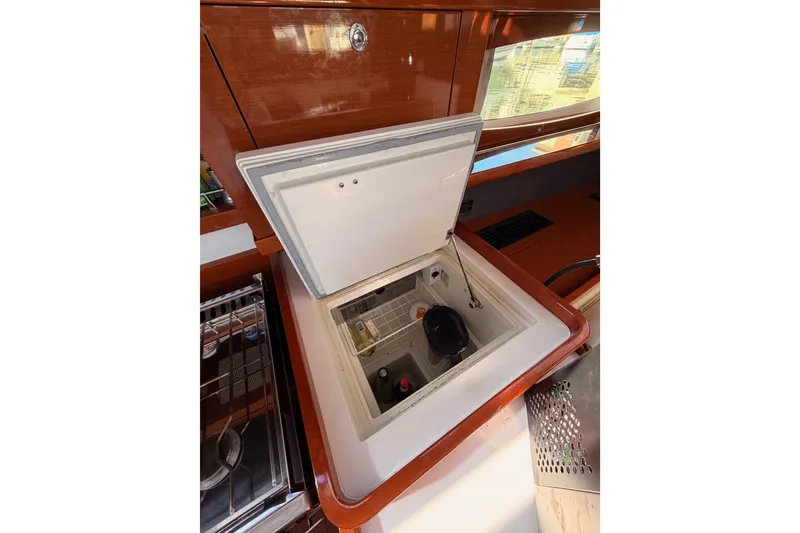 Slide: The Image of Beneteau Oceanis Yacht 60 (2015) interior with open storage compartment in the galley. - 44