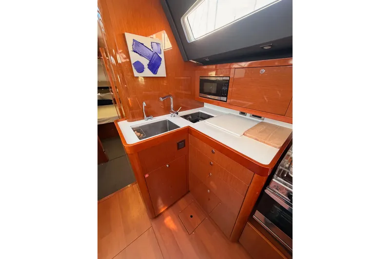 Slide: The Image of Modern kitchen interior of 2015 Beneteau Oceanis Yacht 60 with wood finish and appliances. - 46