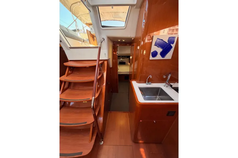 Slide: The Image of Luxurious interior of 2015 Beneteau Oceanis Yacht 60 with wooden stairs and modern kitchenette. - 47