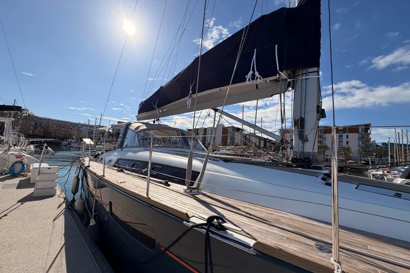 Slide: The Image of Beneteau Oceanis Yacht 60, 2015 model, docked under a sunny sky in a marina. - 6