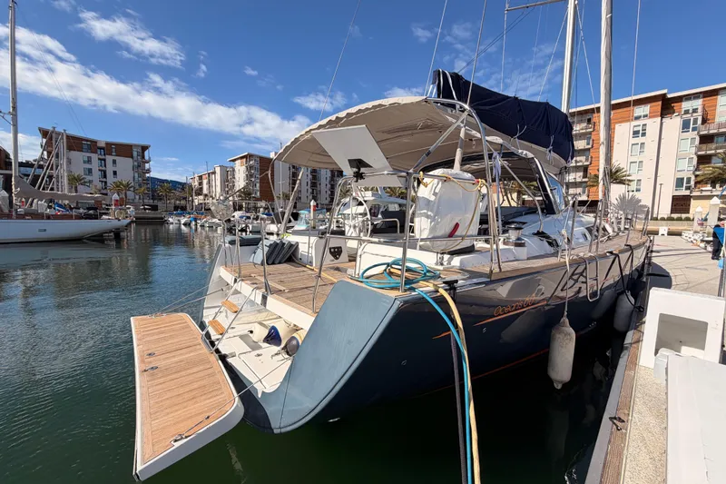 Slide: The Image of 2015 Beneteau Oceanis Yacht 60 docked in a marina under a clear blue sky. - 8