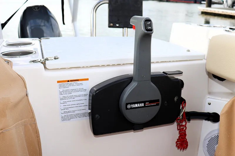 Slide: The Image of Yamaha throttle control on 2021 Ranger Tugs R-27 boat, featuring cup holders and safety warning label. - 11
