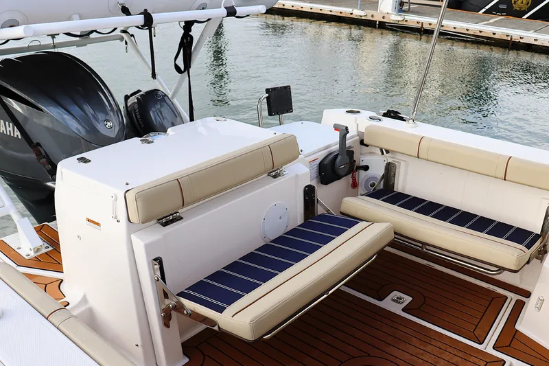 Slide: The Image of 2021 Ranger Tugs R-27 boat interior with cushioned seating and Yamaha engine. - 13