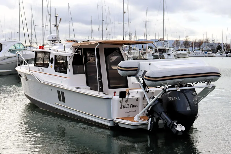 Slide: The Image of 2021 Ranger Tugs R-27 boat docked, featuring Yamaha outboard motor and inflatable dinghy. - 4