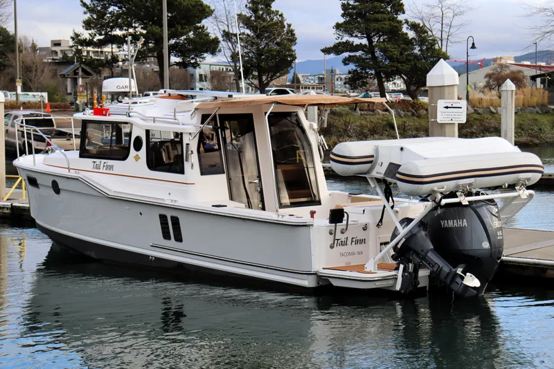 Slide: The Image of 2021 Ranger Tugs R-27 boat docked with Yamaha outboard motor, scenic marina background. - 5