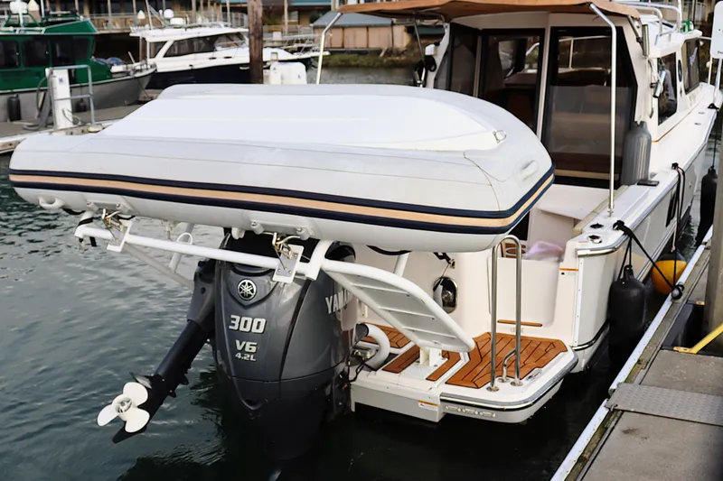 Slide: The Image of 2021 Ranger Tugs R-27 with Yamaha 300 V6 outboard motor and inflatable boat at dock. - 6