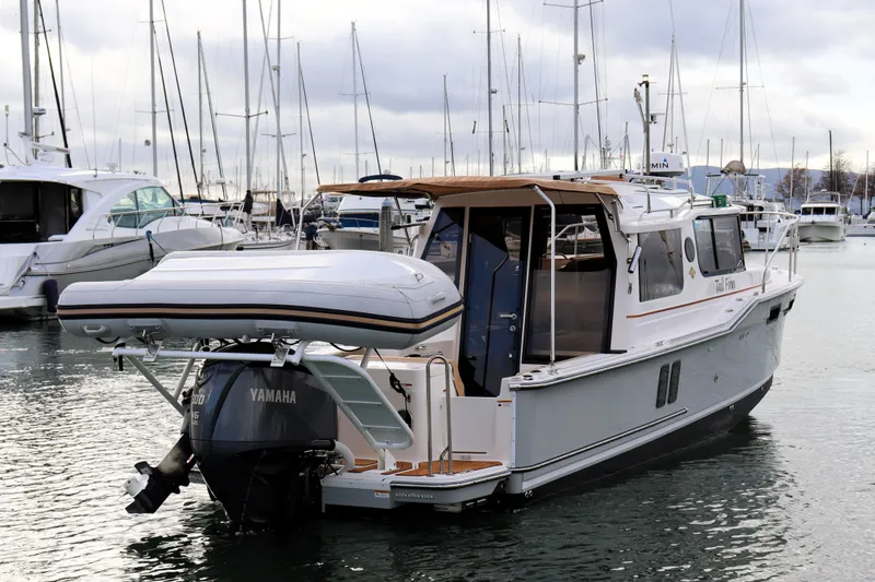 Slide: The Image of 2021 Ranger Tugs R-27 boat docked in marina, featuring Yamaha outboard motor. - 7