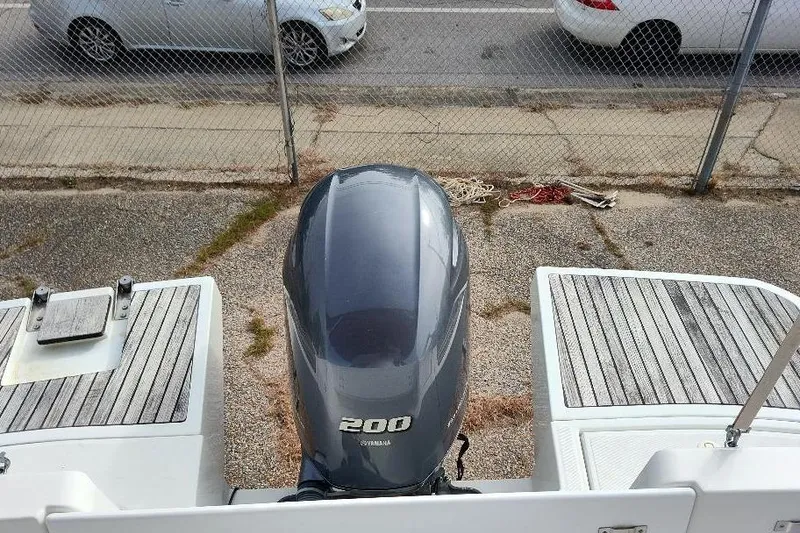 Slide: The Image of 2017 Jeanneau Merry Fisher 795 with Yamaha 200 outboard motor, parked near a fence. - 11