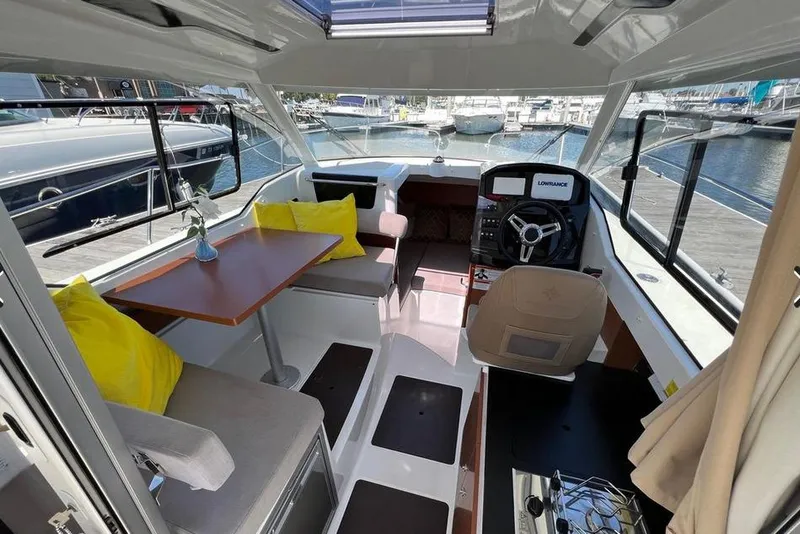 Slide: The Image of Interior of 2017 Jeanneau Merry Fisher 795 boat with seating, table, and helm. - 19