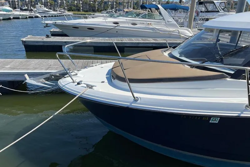 Slide: The Image of 2017 Jeanneau Merry Fisher 795 docked at marina, featuring sleek design and spacious deck. - 2