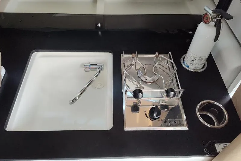 Slide: The Image of Compact kitchen area in 2017 Jeanneau Merry Fisher 795 boat with sink and stove. - 21