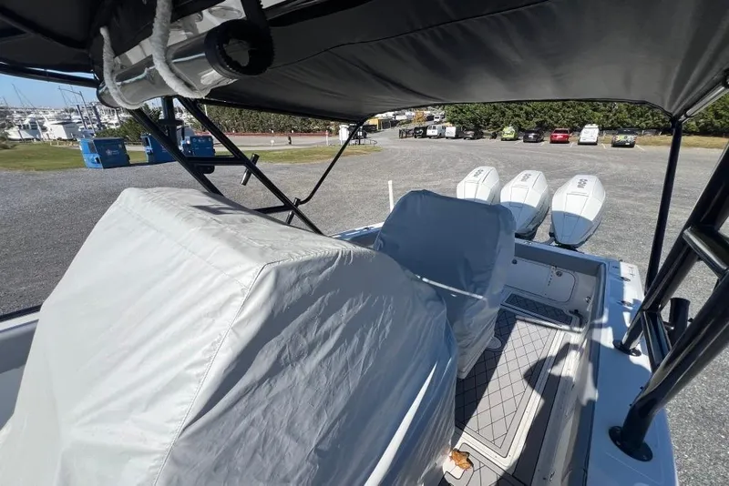 Slide: The Image of 2006 Dakota 36 Open boat with covered seats and triple outboard engines. - 23