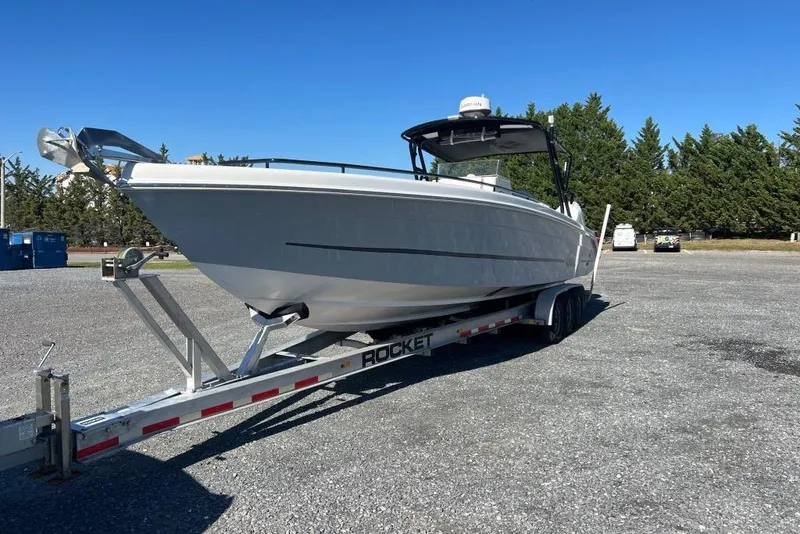 Slide: The Image of 2006 Dakota 36 Open boat on trailer in parking lot, clear sky background. - 5