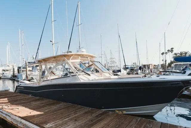 The Image of 2021 Grady-White Freedom 307 boat docked at a marina with sailboats in the background. - 0