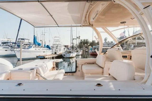 Slide: The Image of 2021 Grady-White Freedom 307 boat interior at marina, showcasing seating and canopy. - 3