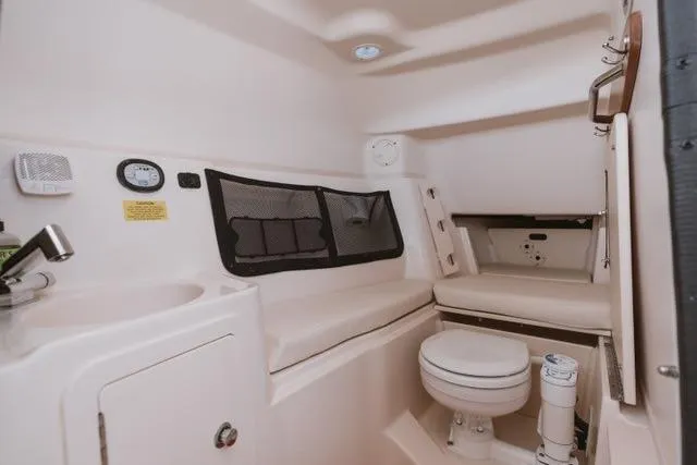 Slide: The Image of 2021 Grady-White Freedom 307 boat interior with seating and compact toilet area. - 5