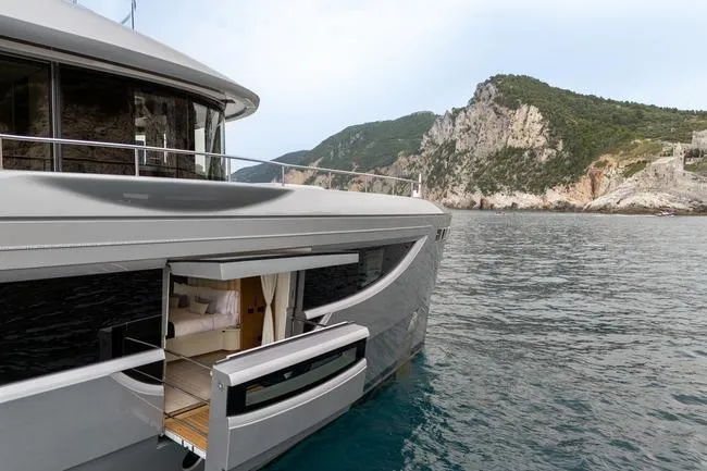 Slide: The Image of 2024 Benetti Oasis 34M yacht with open side deck, scenic coastal backdrop. - 24