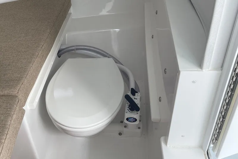 Slide: The Image of 2026 Steiger Craft 28 Hawaii boat interior with toilet and cushioned seating. - 16