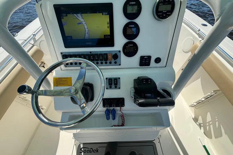 Slide: The Image of 2019 Key West 244 Center Console boat dashboard with steering wheel and navigation controls. - 11