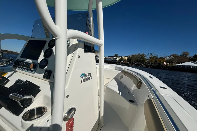 Slide: The Image of 2019 Key West 244 Center Console boat on water, featuring control panel and seating area. - 20