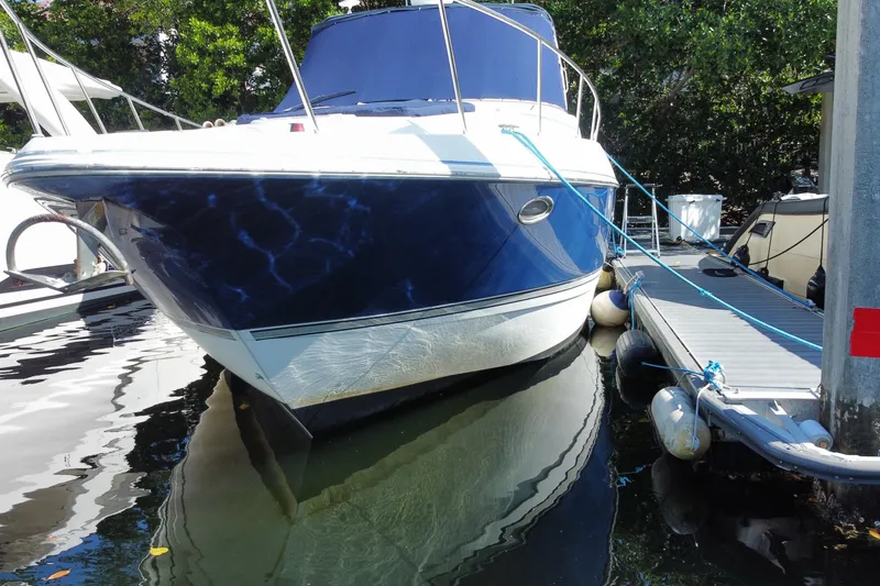 Slide: The Image of 2007 Cruisers Yachts 370 Express docked, featuring sleek blue and white design. - 11