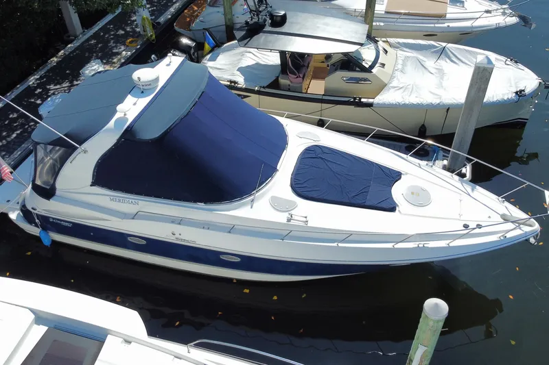 Slide: The Image of 2007 Cruisers Yachts 370 Express docked, featuring blue and white design with covered deck. - 19