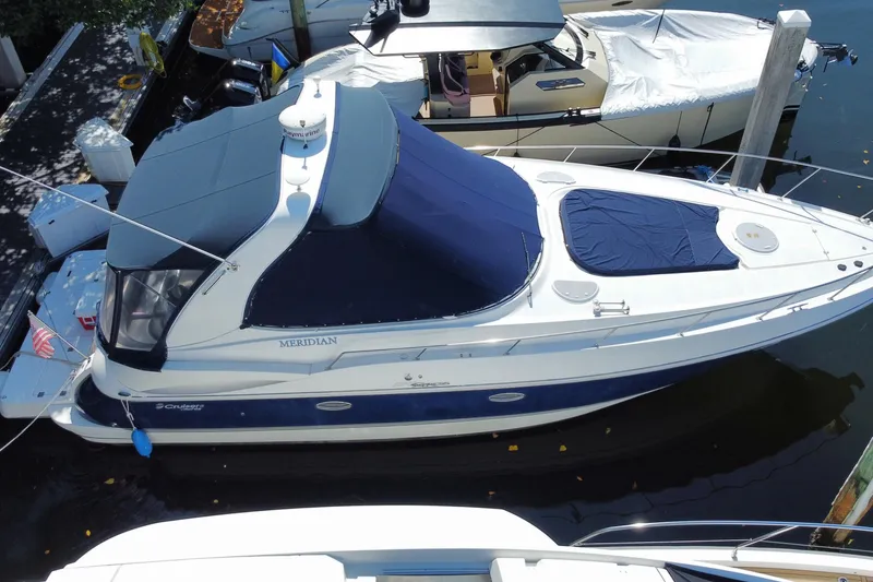 Slide: The Image of 2007 Cruisers Yachts 370 Express docked, featuring blue and white design with covered deck. - 10