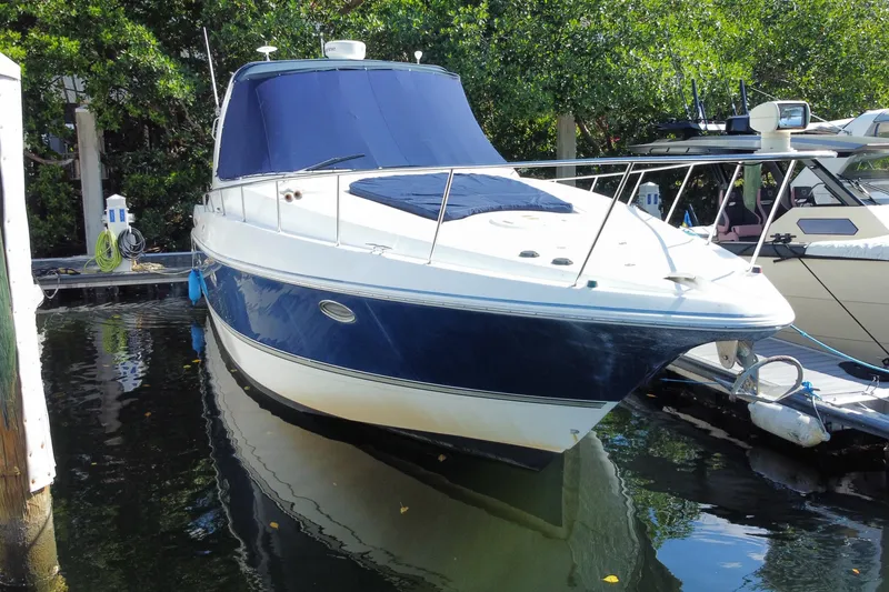 Slide: The Image of 2007 Cruisers Yachts 370 Express docked, featuring sleek design and blue hull. - 14