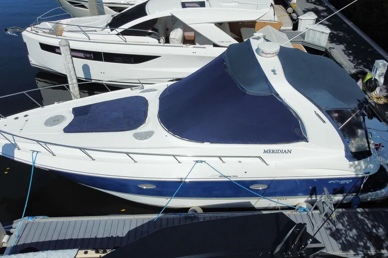 Slide: The Image of 2007 Cruisers Yachts 370 Express docked, featuring blue and white design with covered deck. - 2